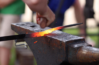 Hammering glowing iron on an anvil